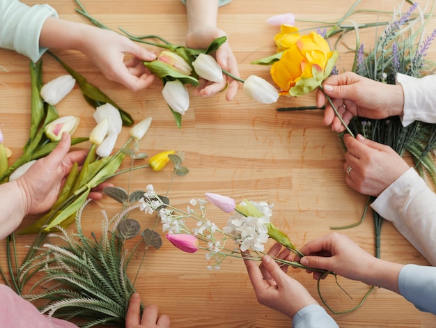 Manos de mujer alta vista con flores de primavera