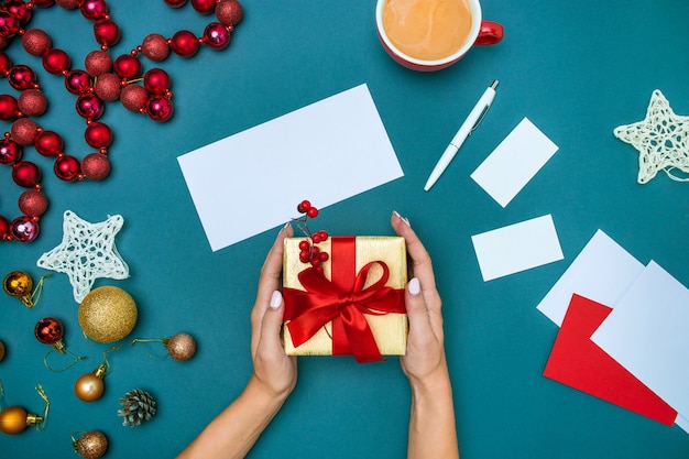 Manos de mujer y caja de regalo de Navidad.