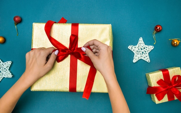 Manos de mujer decorar caja de regalo de Navidad.