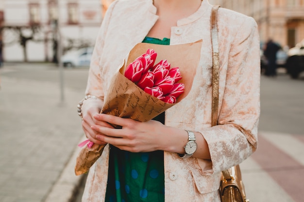 Manos de mujer elegante con ramo de flores