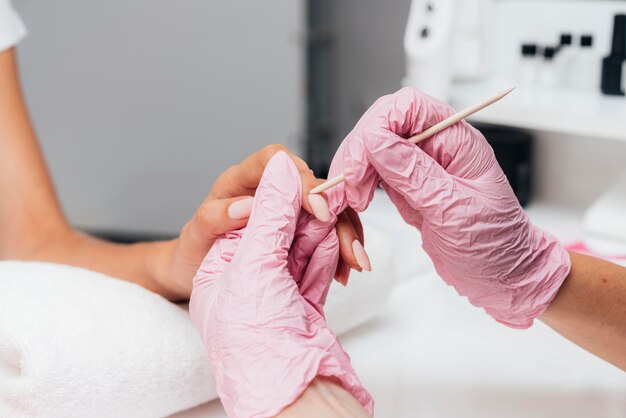 Manos de mujer hermosa y guantes de protección rosa