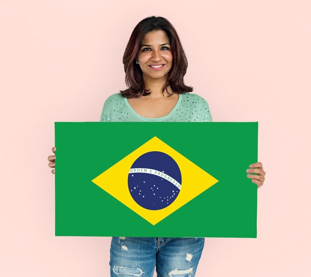 Manos de mujer sostienen el patriotismo de la bandera de Brasil