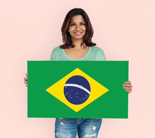 Manos de mujer sostienen el patriotismo de la bandera de Brasil