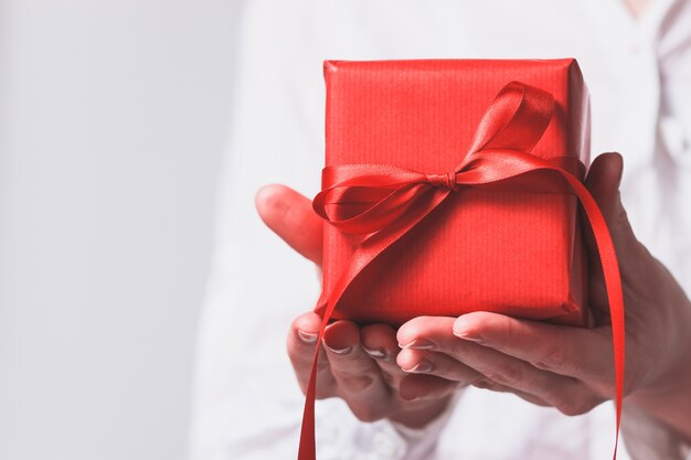 Manos de mujer sujetando un regalo rojo