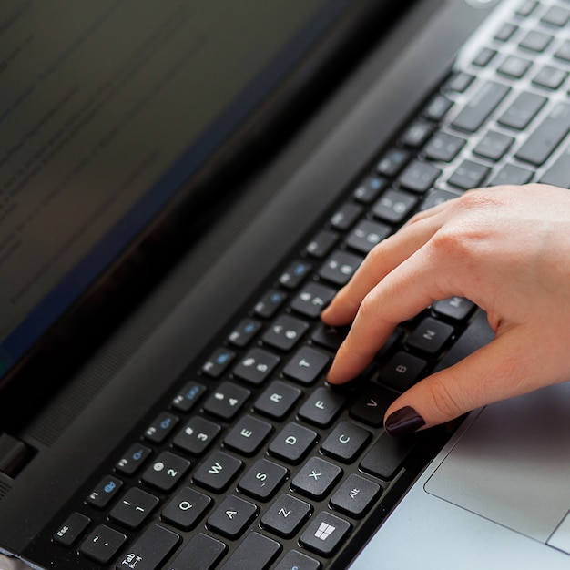 Manos de mujer en el teclado del portátil