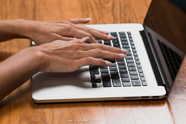 Manos de mujer trabajando en la computadora portátil