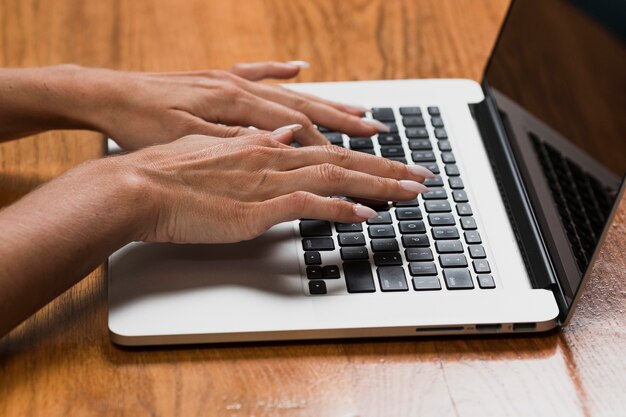 Manos de mujer trabajando en la computadora portátil