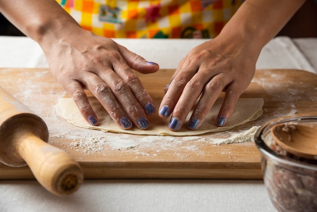 Las manos de las mujeres hacen masa para gutab plato azerbaiyano.
