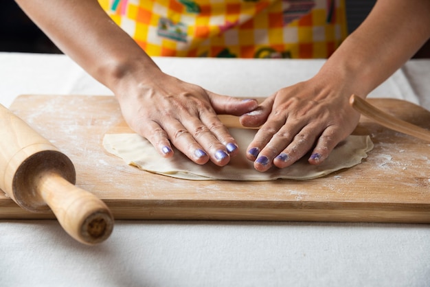 Las manos de las mujeres hacen masa para gutab plato azerbaiyano.