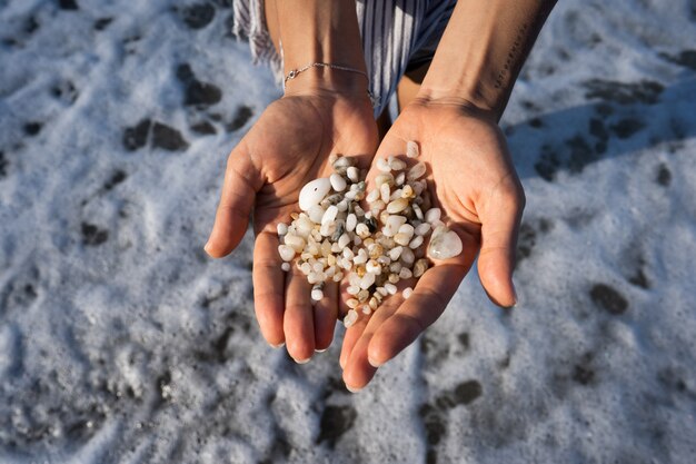 Las manos de las mujeres sostienen muchas piedras pequeñas