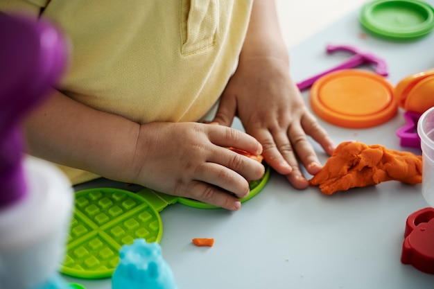 Foto gratuita manos de niño de alto ángulo con plastilina