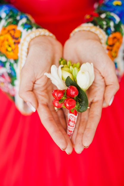 Las manos de la novia mantienen el boutonniere de su novio