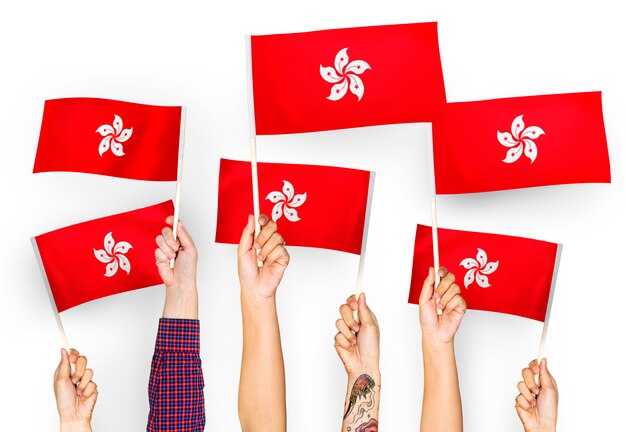 Manos ondeando banderas de Hong Kong