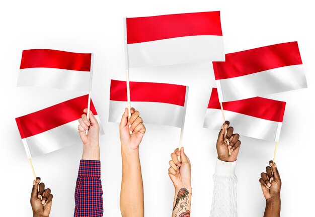 Manos ondeando banderas de Indonesia