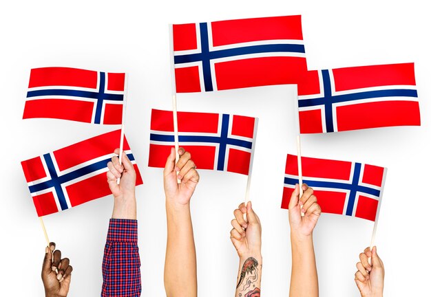 Manos ondeando banderas de Noruega