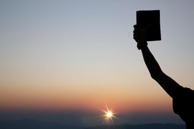 Manos de oración espiritual sosteniendo la biblia.