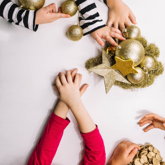 Foto gratuita manos y ornamentos dorados de navidad