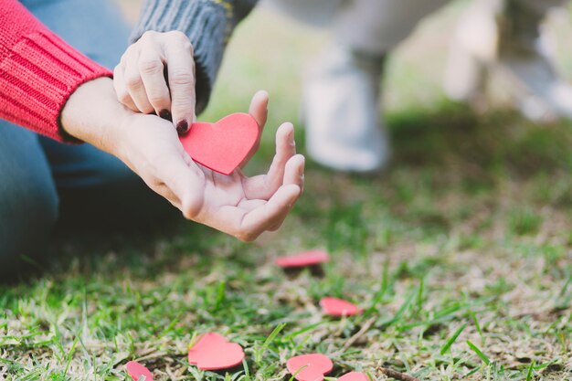 Manos de la pareja con corazón de papel