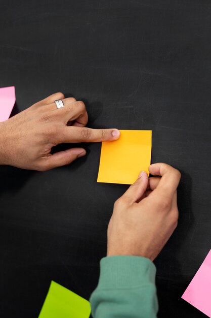 Manos pegadas a un post-it amarillo a bordo