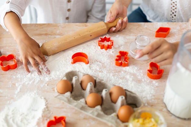 Manos preparando galletas con rodillo de cocina