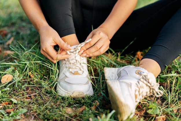 Foto gratuita manos de primer plano atando los cordones de los zapatos