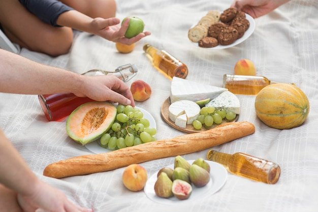 Manos de primer plano con comida en picnic