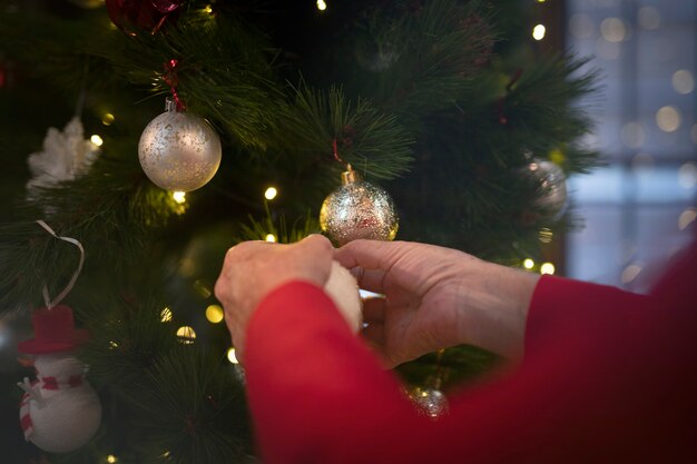 Manos de primer plano configurando el árbol de navidad
