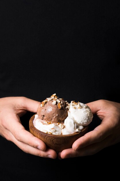 Manos de primer plano con deliciosas cucharadas de gelato