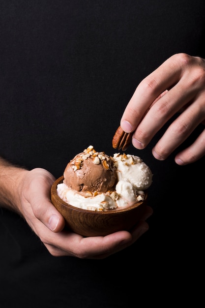 Manos de primer plano con deliciosas cucharadas de gelato