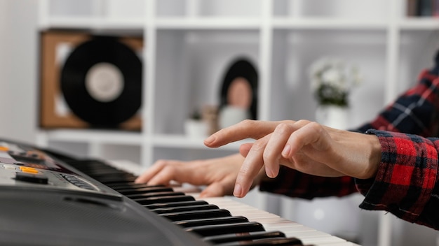 Manos de primer plano jugando al piano digital