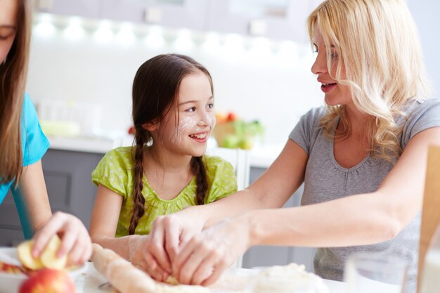 Manos en primer plano de mujer preparando masa para pizza