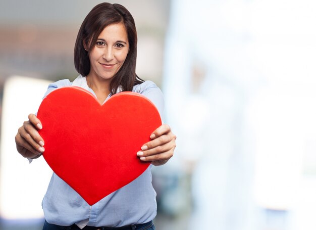 Manos primer plano de la mujer que muestra un corazón rojo