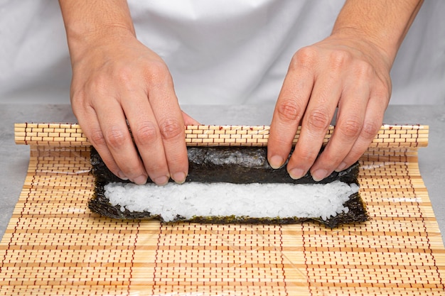 Manos de primer plano preparando delicioso sushi