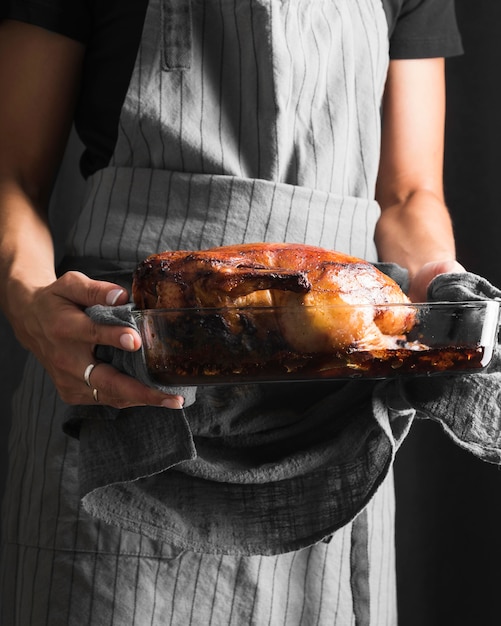 Manos de primer plano sosteniendo la bandeja de pavo