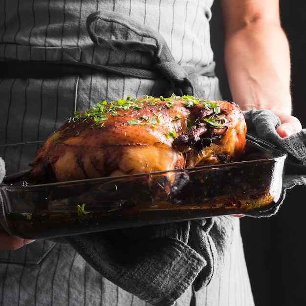 Manos de primer plano sosteniendo la bandeja con pavo