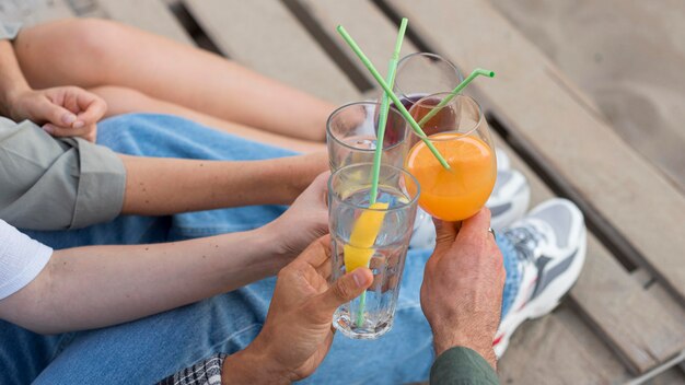 Manos de primer plano sosteniendo bebidas