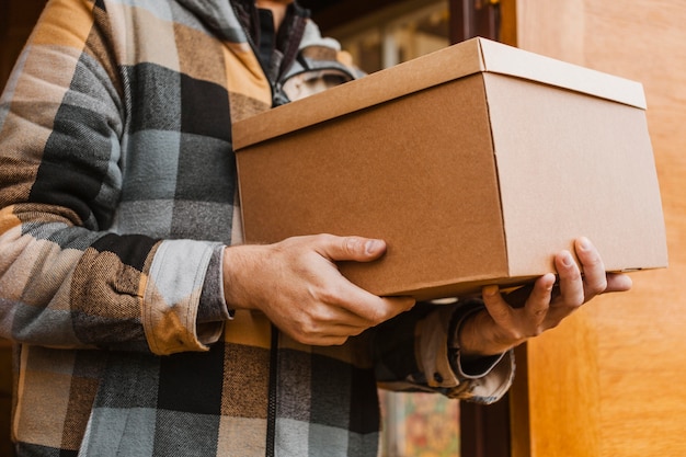 Manos de primer plano sosteniendo la caja