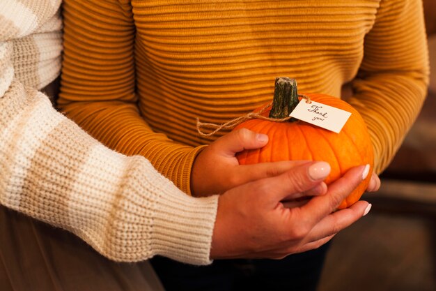 Manos de primer plano sosteniendo calabaza