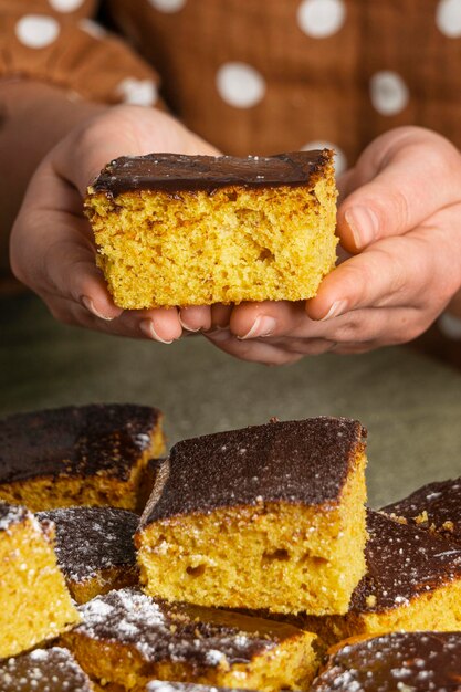 Manos de primer plano sosteniendo delicioso pastel