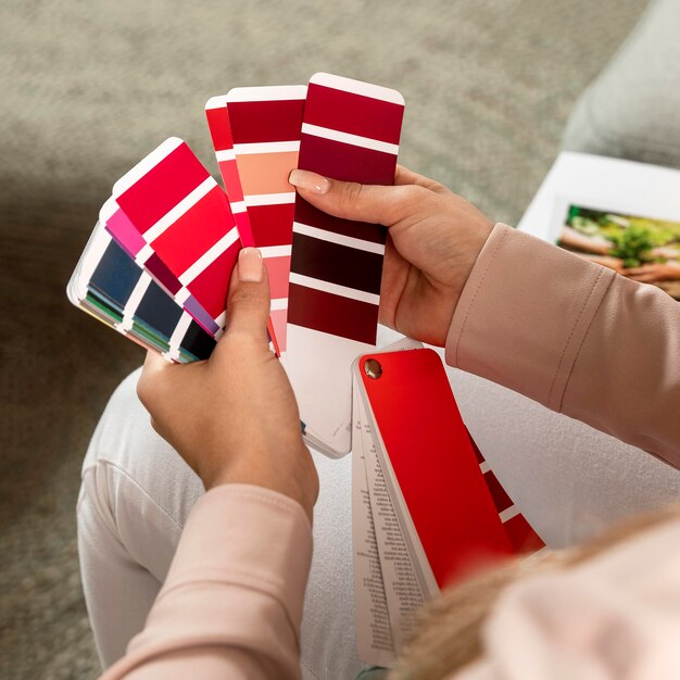 Manos de primer plano sosteniendo paletas de colores