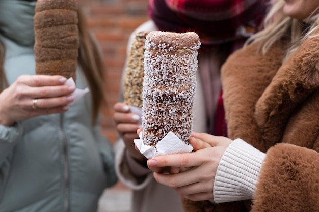 Foto gratuita manos de primer plano sosteniendo pasteles de chimenea