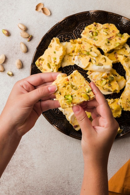 Manos de primer plano sosteniendo la pieza de comida