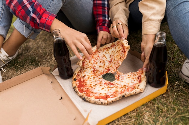 Manos de primer plano sosteniendo pizza