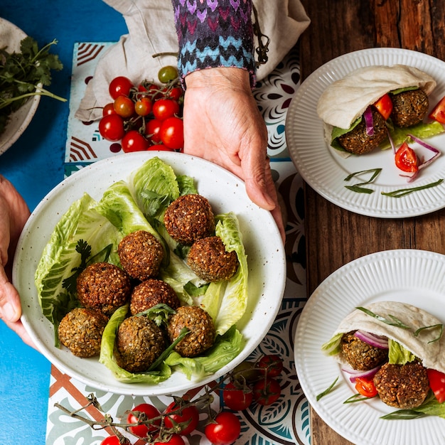 Foto gratuita manos de primer plano sosteniendo el plato con comida judía