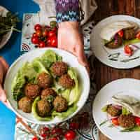 Foto gratuita manos de primer plano sosteniendo el plato con comida judía