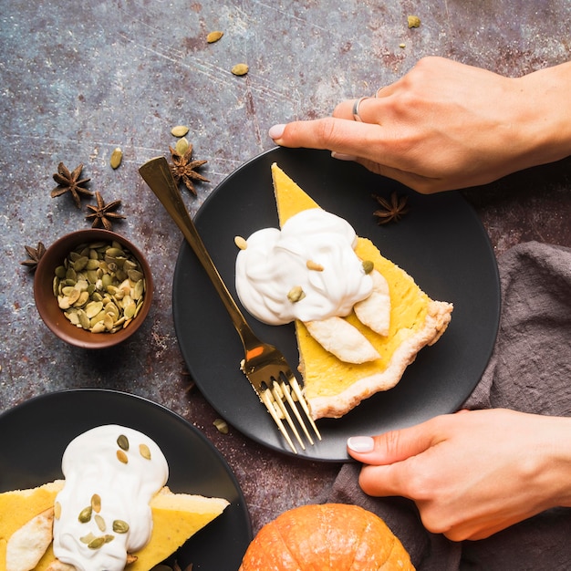 Foto gratuita manos de primer plano sosteniendo un plato de pastel