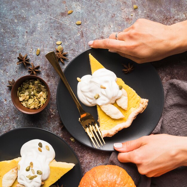 Manos de primer plano sosteniendo un plato de pastel