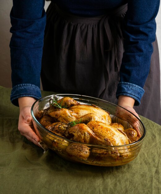 Manos de primer plano sosteniendo plato de pollo