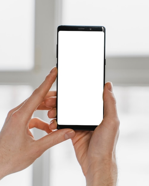 Manos de primer plano sosteniendo smartphone