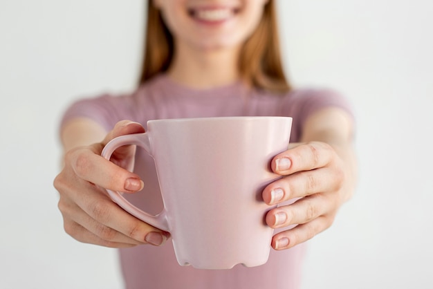 Manos de primer plano sosteniendo la taza